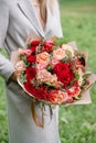 Lovely woman holding a beautiful autumn bouquet. flower arrangement with carnations and red garden roses. Color pink Royalty Free Stock Photo