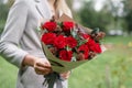 Lovely woman holding a beautiful autumn bouquet. flower arrangement with eucalyptus and red garden roses. Color pink