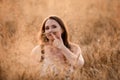 Charming woman posing in field playing with rye ear