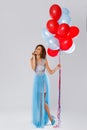 Woman wearing beautiful dress with a lot of colorful balloons