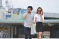 Lovely young Asian couple carrying colorful shopping bags on city street in weekend Royalty Free Stock Photo