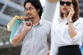 Lovely young Asian couple carrying colorful shopping bags on city street in weekend Royalty Free Stock Photo