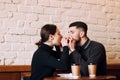 Lovely young couple sitting in cafe, feeding a croissant to each other Royalty Free Stock Photo