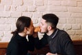 Lovely young couple sitting in cafe, feeding a croissant to each other Royalty Free Stock Photo