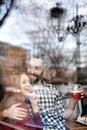 Lovely young couple spending time together in cafe, view through window Royalty Free Stock Photo