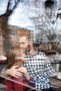 Lovely young couple spending time together in cafe, view through window Royalty Free Stock Photo