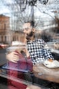 Lovely young couple spending time together in cafe, view through window Royalty Free Stock Photo