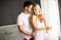 Lovely young couple standing by the window at morning Royalty Free Stock Photo