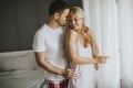 Lovely young couple standing by the window at morning Royalty Free Stock Photo