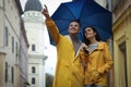 Lovely young couple with umbrella walking under rain on city street Royalty Free Stock Photo