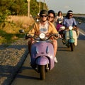 Lovely young couple wearing protective helmets riding a vintage scooter outside the city Royalty Free Stock Photo