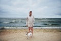 Woman in jacket looking at dog near sea Royalty Free Stock Photo