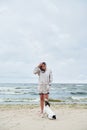 Woman in jacket looking at dog near sea Royalty Free Stock Photo