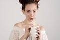 Lovely young girl is drinking with a straw. studio shot with light background. Royalty Free Stock Photo