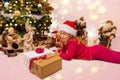 pretty little girl with a christmas hat waiting at the foot of the Christmas tree for the opening of presents Royalty Free Stock Photo