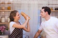 Lovely young happy caucasian couple or lover playful fight in kitchen together. Funny boyfriend and girlfriend have fun in kitchen Royalty Free Stock Photo