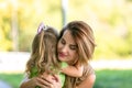 Lovely young mom and daughter in warm sunny summer day. Happy family mother and child little daughter hugging and Royalty Free Stock Photo