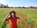 Lovely young romantic woman in straw hat on poppy flower field posing on background summer. Wearing straw hat. Soft Royalty Free Stock Photo