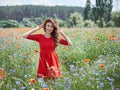 Lovely young romantic woman in straw hat on poppy flower field posing on background summer. Wearing straw hat. Soft Royalty Free Stock Photo