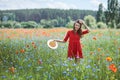 Lovely young romantic woman in straw hat on poppy flower field posing on background summer. Wearing straw hat. Soft Royalty Free Stock Photo