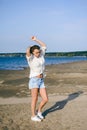 Woman with curly hair, the romance of youth, a journey walk on a warm summer sunny day on a sandy beach with water Royalty Free Stock Photo