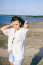 Woman with curly hair, the romance of youth, a journey walk on a warm summer sunny day on a sandy beach with water Royalty Free Stock Photo