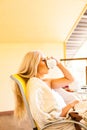 Lovely young woman drinking her morning coffee, sitting on the chair and looking out the window. Morning and waking Royalty Free Stock Photo