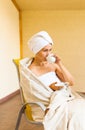 Lovely young woman drinking her morning coffee, sitting on the chair and looking out the window. Morning and waking Royalty Free Stock Photo