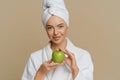 Lovely young woman has refreshed skin after taking bath dressed in dressing gown wrapped towel Royalty Free Stock Photo