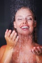 Lovely young woman having a bath under a shower. Closeup of a happy cute female having a bath under a shower , dark Royalty Free Stock Photo