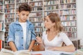 Lovely young woman and her son at the library