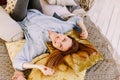 Lovely young woman is lying at home in a bright bed and smiling. Photo in bright, sunny, yellow colors