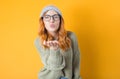 Lovely young woman send kiss to you, isolated on yellow background. Beautiful lovely woman kissing Royalty Free Stock Photo