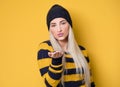Lovely young woman send kiss to you, model wearing woolen cap and sweater,  on yellow background. Beautiful lovely woman Royalty Free Stock Photo