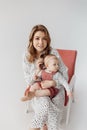 Lovely young woman posing in the studio with her lovely baby girl. Happy mother, tenderly hugging her adorable daughter Royalty Free Stock Photo