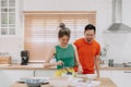 Lover couple. Funny shocked face reaction of husband looking at wife cooking.