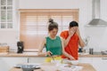 Lover couple. Funny shocked face reaction of husband looking at wife cooking.