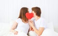 Lover couple kissing with a red heart in bed Royalty Free Stock Photo