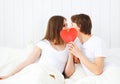 Lover couple kissing with a red heart in bed Royalty Free Stock Photo