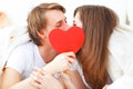 Lover couple kissing with a red heart in bed Royalty Free Stock Photo