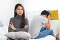 Lover couple relationship problems. Sad young wife sitting on the bed back to back from husband after argument Royalty Free Stock Photo