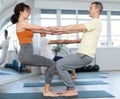 Lovers of active lifestyle pair yoga doing double power pair pose in gym Royalty Free Stock Photo