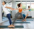 Lovers of active lifestyle perform pair yoga backbend balance pose in gym Royalty Free Stock Photo