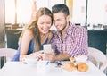 Lovers in a bar looking at cell phone Royalty Free Stock Photo