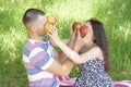 Lovers boy and girl dabble apples close each others eyes. emotions. summer picnic