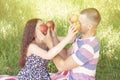 Lovers boy and girl dabble apples close each others eyes. emotions. summer picnic