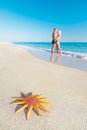 Lovers couple at sandy sea beach with big red starfish Royalty Free Stock Photo