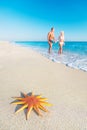 Lovers couple at sandy sea beach with red starfish Royalty Free Stock Photo