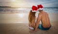 Lovers couple in santa hats at tropical sandy beach Royalty Free Stock Photo