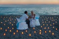 Lovers couple share a romantic dinner on sea beach